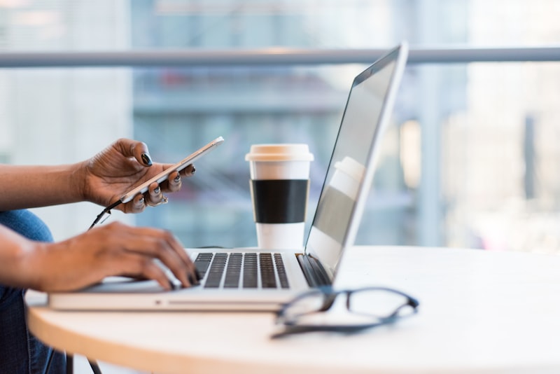 Person working on smartphone and laptop
